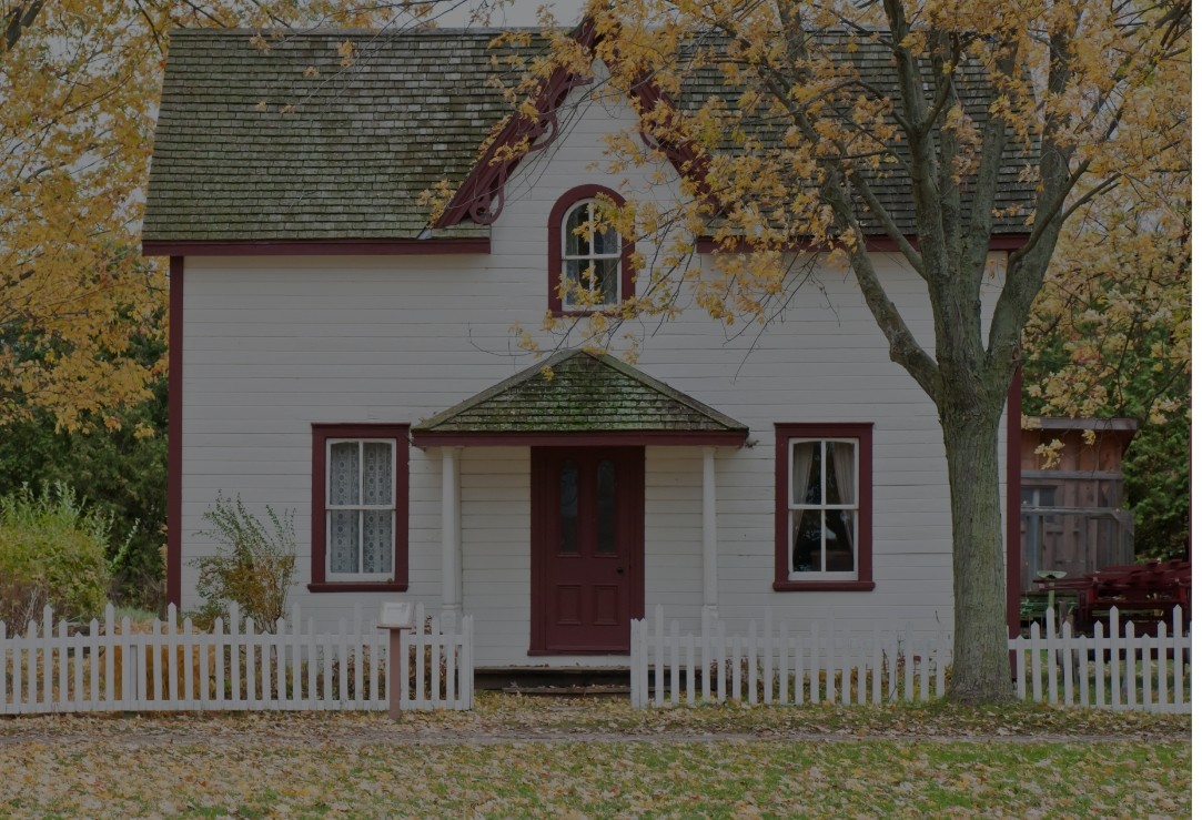 Old white house with tree during autumn